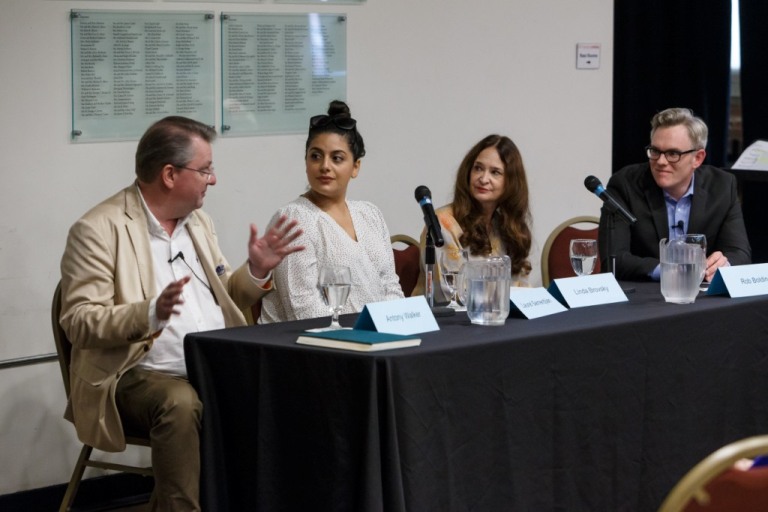 Antony Walker gestures beside three fellow panelists at a table at a 2018 Opera Up Close
