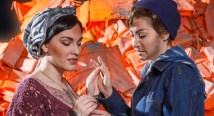 Ilia in a headscarf and Idamante in a denim jacket clasp hands in Pittsburgh Opera's afterWARds