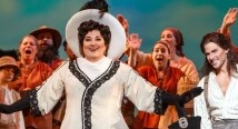Paula in a white dress and wide hat sings amid the riverboat chorus in Pittsburgh Opera's Florencia en el Amazonas