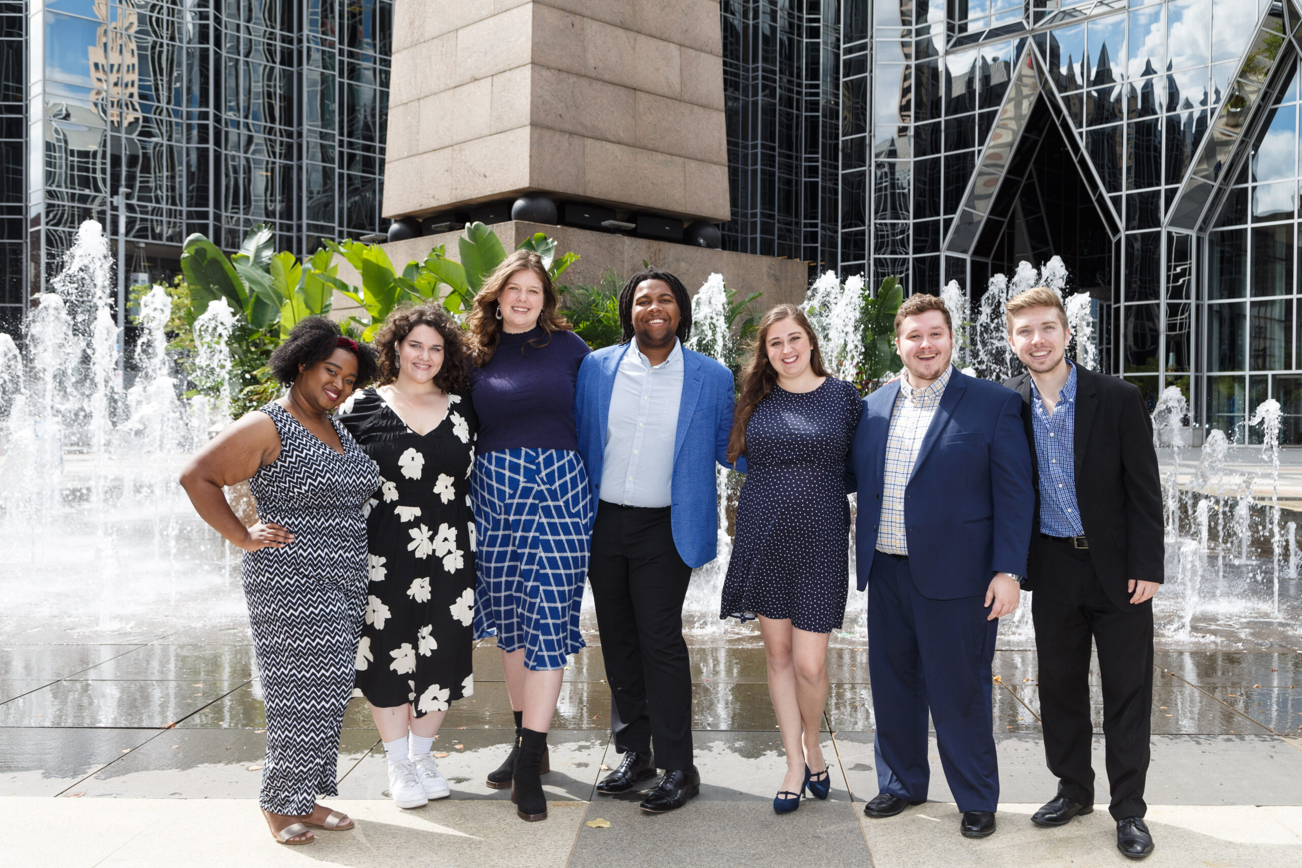 Seven Pittsburgh Opera Resident Artists pose before the fountains of PPG Place in 2022