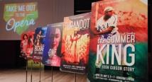 Season posters on easels for Take Me Out to the Opera, As One, Turandot, and The Summer King on a stage