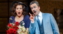 Norina in a black hat holds red roses as Malatesta in a blue suit raises a finger in Pittsburgh Opera's Don Pasquale