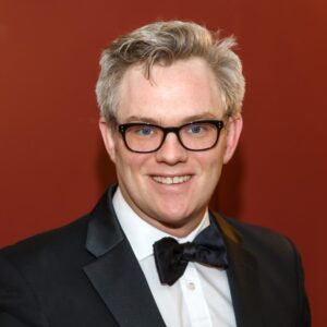 Robert Boldin in a tuxedo and glasses, portrait