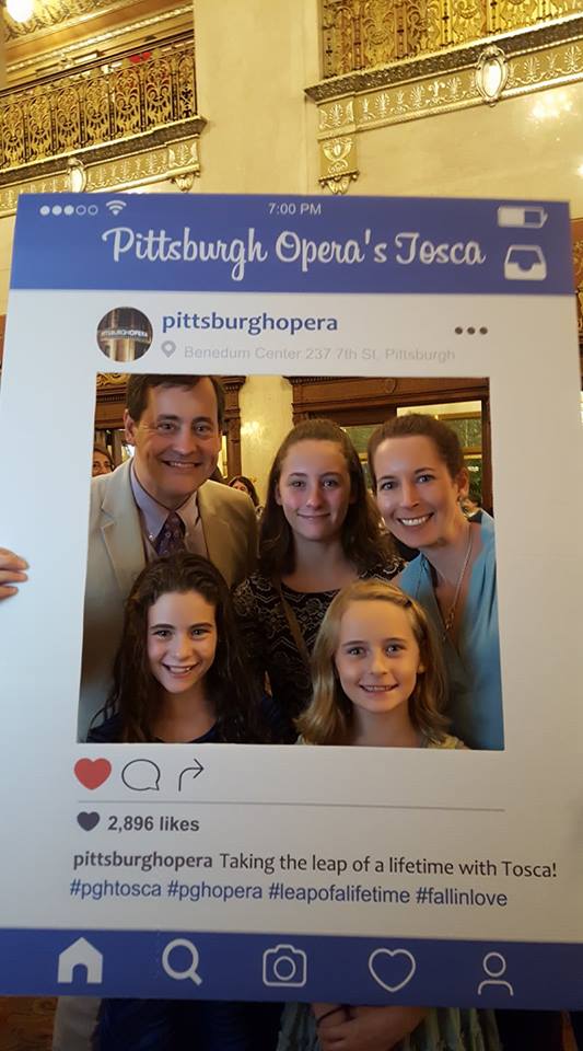 A family pose for a picture while holding an instagram post cut-out.
