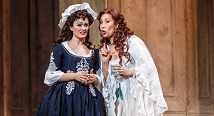 Susanna in a blue gown and the Countess in white lace confer in Pittsburgh Opera's The Marriage of Figaro, 2022