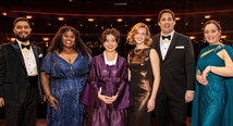 Six Metropolitan Opera Laffont Competition finalists in gowns and tuxedos on stage, Shannon Crowley at center