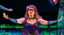 Maire Therese Carmack as Juno in a purple gown and crown spreads her arms in Pittsburgh Opera's Semele