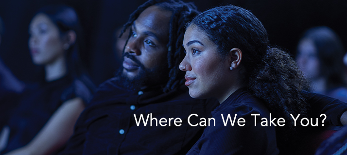 A couple watches from theater seats in blue light; text: Where Can We Take You?