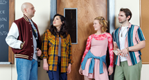 A drama teacher in a letterman jacket faces three students by a classroom door in Pittsburgh Opera's Time to Act