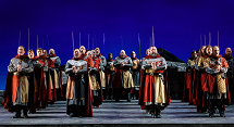 Soldiers in chain mail and red capes hold pikes upright against a blue sky in Pittsburgh Opera's Il Trovatore