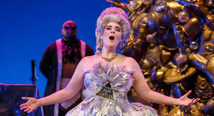 Alcina in a towering white wig and jeweled gown sings before a golden throne in Pittsburgh Opera's Alcina