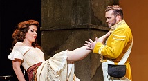 Carmen in a white blouse kicks up her skirt toward Escamillo in a yellow matador jacket in Pittsburgh Opera's Carmen