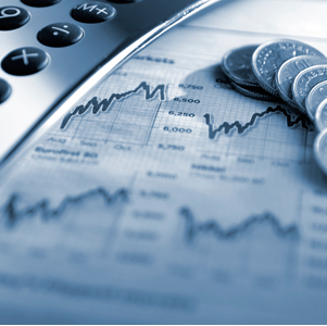 A calculator and stacked coins on a stock chart, tinted blue