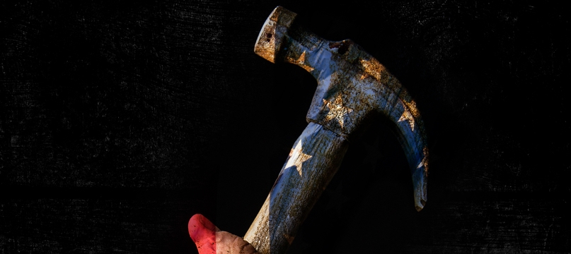 A hand grips a worn hammer painted with the American flag against black; The Last American Hammer key art