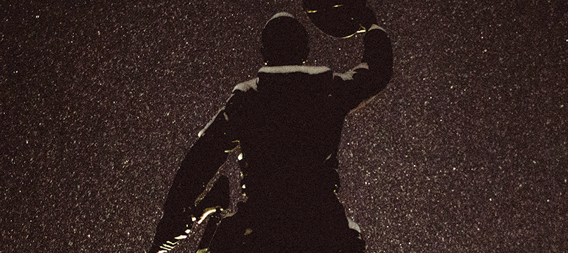Silhouette of a soldier hoisting a child onto his shoulders against a dark speckled sky; Soldier Songs key art